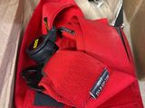 une boîte contenant un ruban rouge et une paire de ciseaux