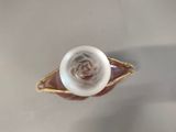 a white rose in the middle of a gold plated ring