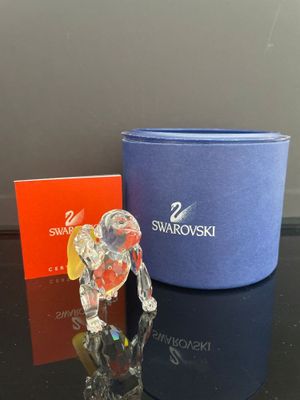 une figurine d'éléphant en verre posée à côté d'une boîte bleue