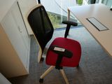 une chaise de bureau rouge placée devant un bureau blanc