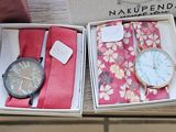 two watches and ties in a box on a table