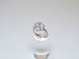 an image of a ring with a white oplite in it on a clear glass stand