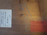 a piece of wood with writing on it and a piece of paper on the table