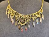 une femme portant un collier en or orné de plumes