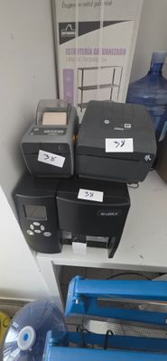 many different printers on a shelf in a room