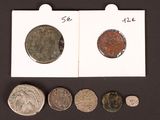 several different coins are shown in a row on a black surface