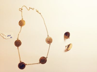 necklace and earrings on a table with a white background