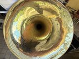 a man standing next to a large brass instrument