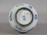 a white and blue vase sitting on a table