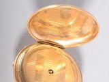 a gold pocket watch with a chain hanging from it ' s side