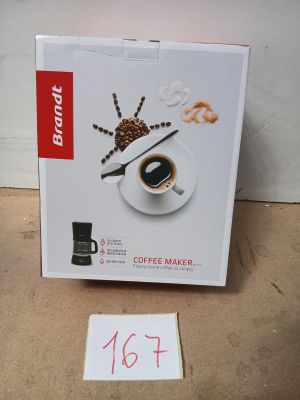 une boîte contenant une cafetière, posée par terre à côté d'un panneau