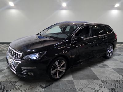 the black car is parked on a checkered floor in the garage