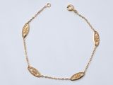 un bracelet en or orné d'un motif de feuilles sur une chaîne