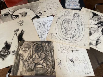 de nombreux dessins posés sur une table avec une chaise