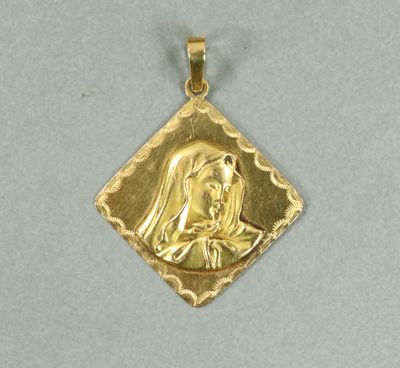 un gros plan d'un pendentif en or représentant une femme, en forme de losange