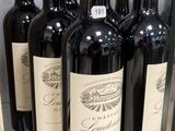 six bouteilles de vin rouge sont exposées dans une vitrine