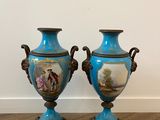 two blue vases sitting on top of a wooden floor next to each other
