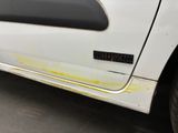 a white truck with rust on the side of it