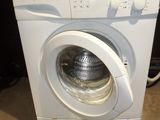 a white washing machine with a bottle of deter on top of it