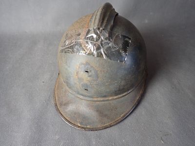 a metal helmet with a bird on it on a table