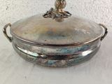 a silver plate with a bird on it on a table