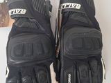 deux paires de gants de moto noirs posées sur une table blanche