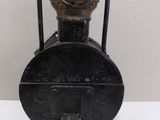 an old black oil lamp sitting on top of a white table