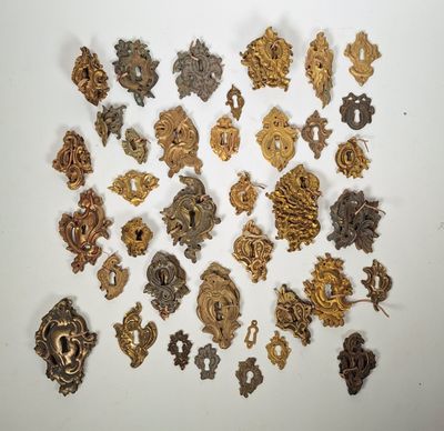 un assortiment d'engrenages anciens en métal disposés sur une surface blanche