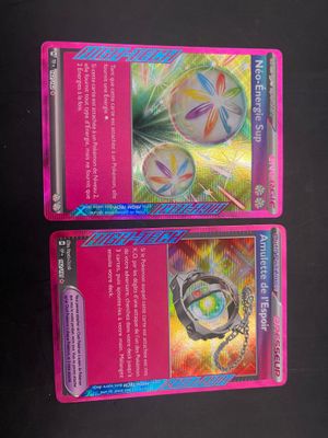 two pink pokemon cards are sitting side by side on a table