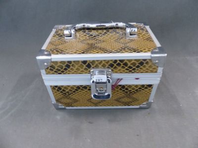 une petite boîte en métal ornée d'un motif imitant une peau de serpent