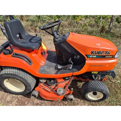 an orange riding lawn mower sitting on top of a grass covered field