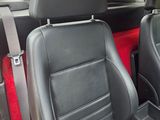 the interior of a car with black leather seats and red carpet