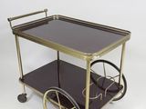 an antique brass and glass bar cart with wheels