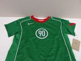the shirt is green and red with a white number on it