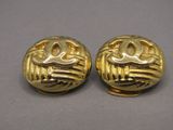 pair of gold tone earrings with a stylized design on each side