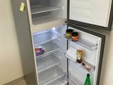 un réfrigérateur dont la porte est ouverte, dans un coin de la pièce