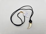 a close up of a necklace on a white surface with a tag