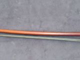 an orange hose attached to the side of a metal pipe