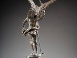 statue of an angel holding a sword on a marble pedestal