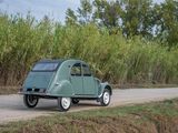a small green car that is parked on the side of the road