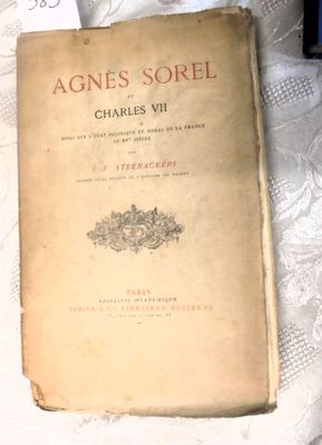 un vieux livre posé sur un lit recouvert de draps blancs