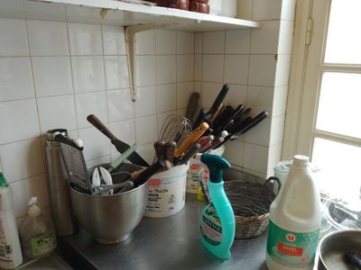 Il y a de nombreux ustensiles de cuisine sur le plan de travail de cette cuisine