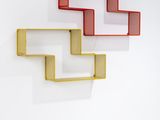 trois étagères fixées au mur, peintes en rouge, jaune et blanc