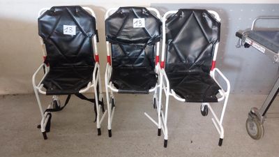 trois chaises pliantes noires et blanches placées les unes à côté des autres dans une pièce