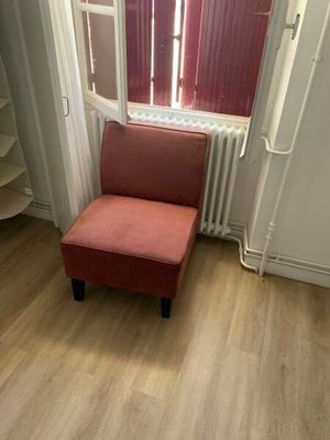 une chaise rouge placée devant une fenêtre