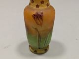 a small vase sitting on a table with a white background