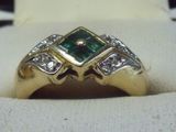 une image d'une bague en or avec une pierre verte