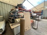 beaucoup de bric-à-brac dans un garage, avec une voiture en arrière-plan