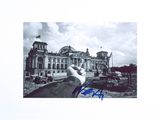 signed photograph of a hand pointing at a building under construction