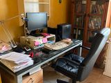 a desk with a computer and a chair in a room